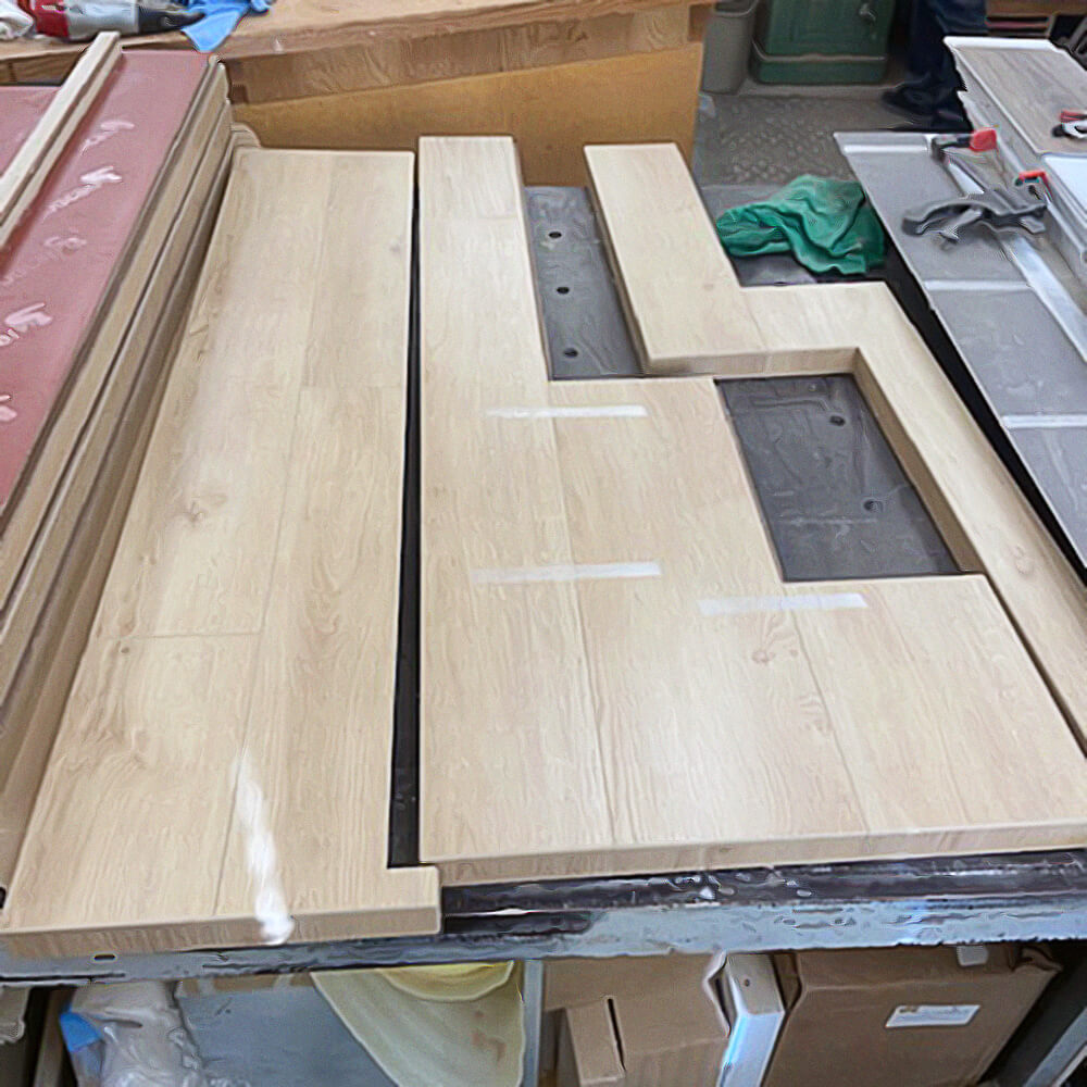 Custom vinyl plank (LVP) stair nosing being manufactured.